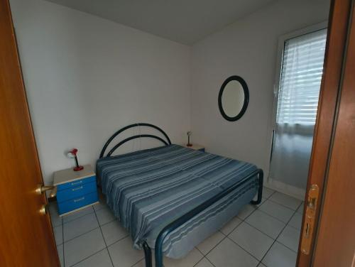 a small bedroom with a bed and a mirror at Cozy flat near the centre of Rosolina Mare in Rosolina Mare