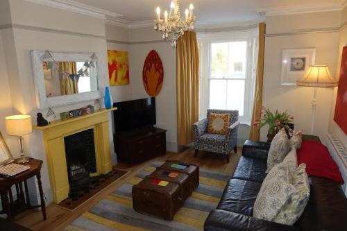 a living room with a couch and a fireplace at Sunshine Villa Broadstairs sleeps 8 close to beach in Broadstairs