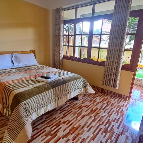a bedroom with a bed and a large window at Hospedaje El Manantial in Chontabamba