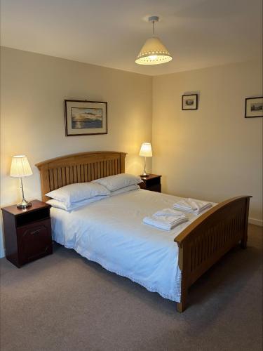 a bedroom with a large bed with two night stands and two lamps at Braehouse cottage in Kilmory
