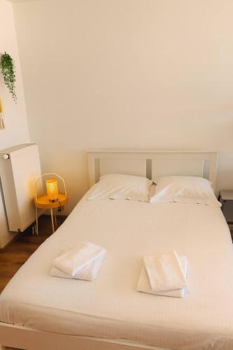 a large white bed with two white pillows on it at Casiola - Beach Studio with Balcony & Sea View in Zeebrugge