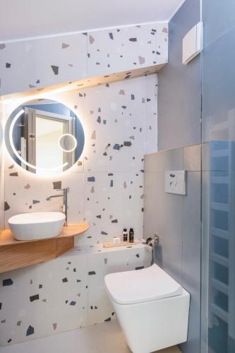 a bathroom with a toilet and a sink and a mirror at Nõs Luxury Rooms in Missolonghi