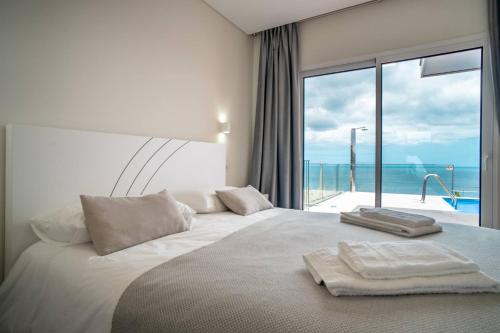 a bedroom with a large bed with a large window at Villa Azinhaga in Gaula