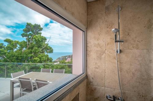 a shower room with a glass window and a table and chairs at Villa Azinhaga in Gaula