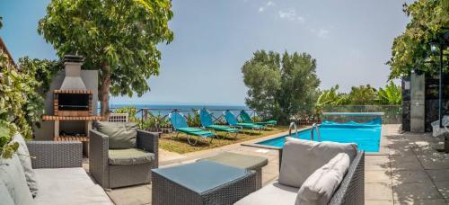 a patio with chairs and a swimming pool at Madeirense Villa in Santa Cruz in Santa Cruz