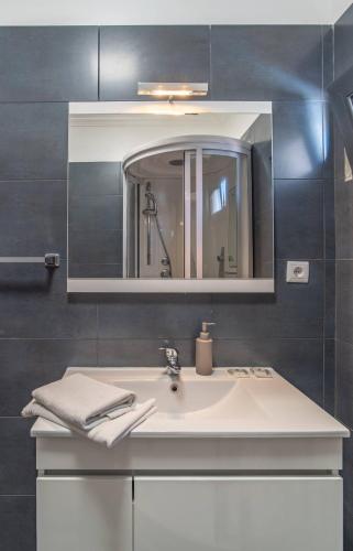 a bathroom with a white sink and a mirror at Camara De Lobos Lux Villa in Câmara de Lobos