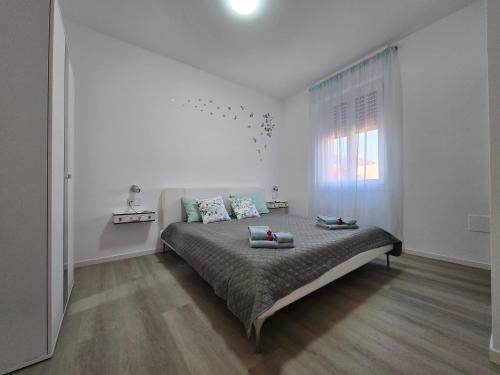 a bedroom with a large bed in a white room at "Felicita" San Francesco lake view Relax Apartment in Lecco
