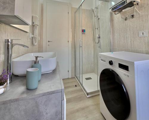 a bathroom with a washing machine and a sink at "Felicita" San Francesco lake view Relax Apartment in Lecco