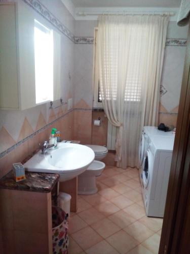 a bathroom with a sink and a washing machine at DIMORA ANTONIANNA in VALLE D'ITRIA in Locorotondo