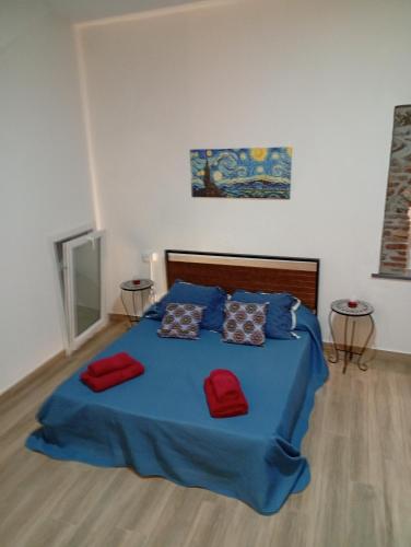 a bedroom with a blue bed with two red pillows at Appartamento rosso blu in Vernazza