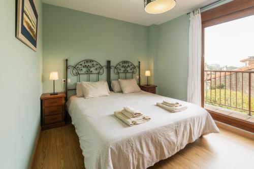 a bedroom with a large bed with towels on it at Casa Llanes (Poo) cerca de la playa - Traudel in Llanes