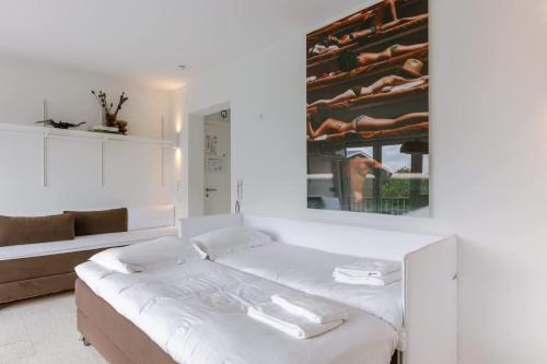 a white room with a bed and a mirror at Sea views - beachfront - in the heart of Knokke-Heist in Knokke-Heist