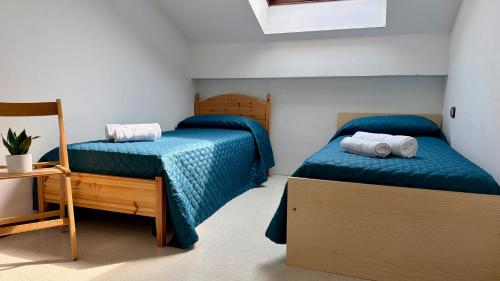a bedroom with two beds and a chair at apartament skyline park residense in Lignano Sabbiadoro