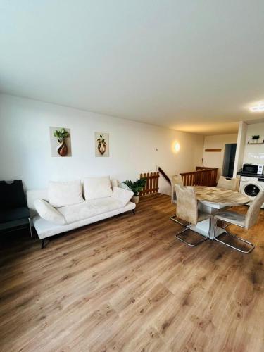 a living room with a white couch and a table at Ferienwohnung Nelli in Sankt Englmar