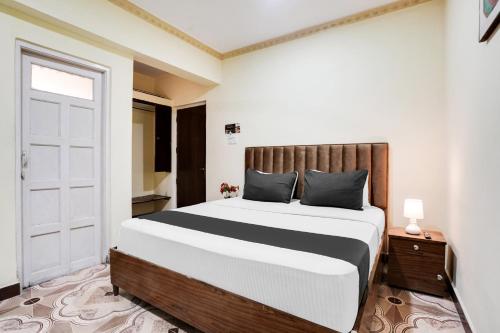 a bedroom with a large bed and a door at Super Collection O Calangute in Goa
