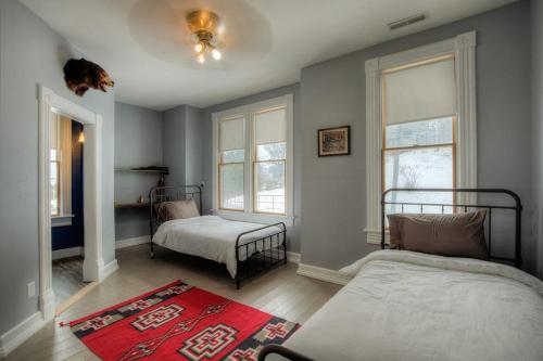 a bedroom with two beds and a red rug at Addie House in Lead