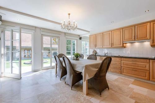 a dining room with a table and chairs in a kitchen at Casiola - Authentic Serene Vacation Hideaway with Pond in Harelbeke