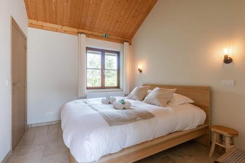 a bedroom with a large bed with two stuffed animals on it at Casiola - Authentic Serene Vacation Hideaway with Pond in Harelbeke
