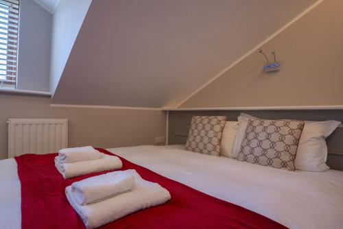 a large white bed with two towels on it at Alensgrove Maisonette A in Leixlip