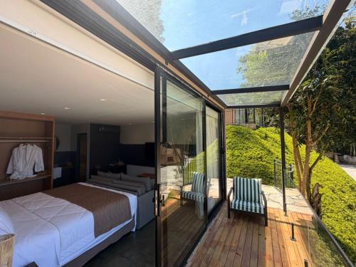 a bedroom with a bed and a sliding glass door at Hotel Boutique Vila don Patto in São Roque