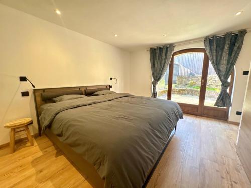 a bedroom with a large bed and a large window at Gîte d'Eléonore in Rupt-sur-Moselle