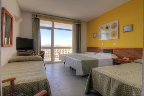 
a hotel room with two beds and a television at Hotel & Spa Entremares in La Manga del Mar Menor
