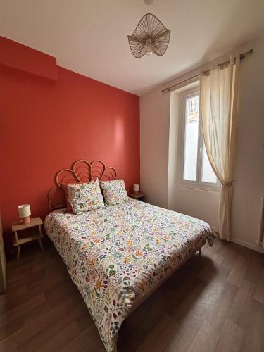 a bedroom with a bed with a red wall at Le jardin secret in Reims