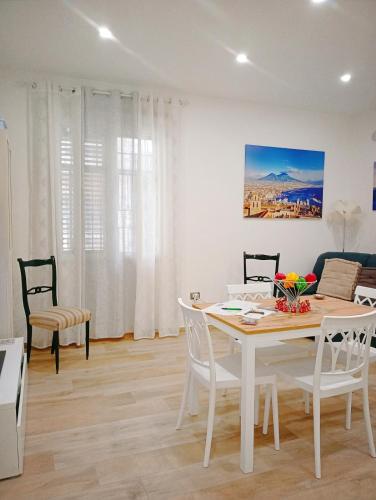 a white dining room with a table and chairs at Trieste Apartment in Reggio di Calabria
