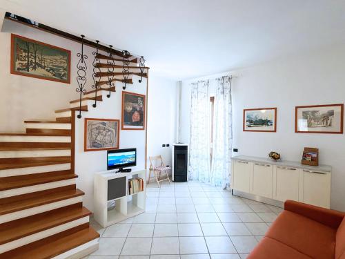 a living room with a staircase and a television at Casa Marlù - ArgonautiVacanze in Porto Azzurro