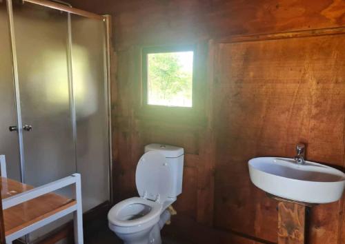 a bathroom with a toilet and a sink at Chobe Lesoma Chalets Hotel in Lesoma