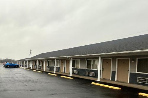 a building with a car parked in a parking lot at Budget Inn by Hotel O Greensville I 70 in Greenville