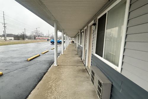 a building with white columns next to a street at Budget Inn by Hotel O Greensville I 70 in Greenville