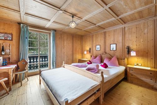 a bedroom with a bed and a desk and a window at Blaa Alm in Altaussee