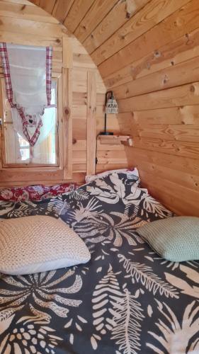 a bedroom with a bed in a wooden cabin at La Cabane douillette in Aups