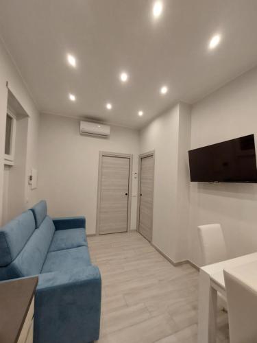 a living room with a blue couch and a flat screen tv at Grazia Nest in Ciampino
