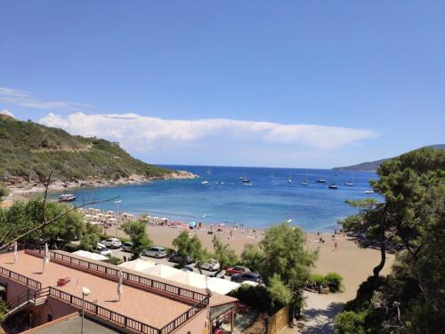a beach with people and boats in the water at Casa Marlù - ArgonautiVacanze in Porto Azzurro