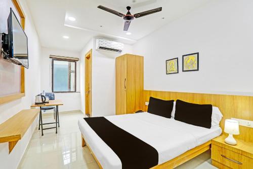 a bedroom with a bed and a desk and a tv at Super Hotel O Raipur in Raipur
