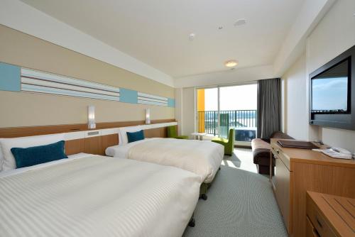 a hotel room with two beds and a flat screen tv at Vessel Hotel Campana Okinawa in Chatan