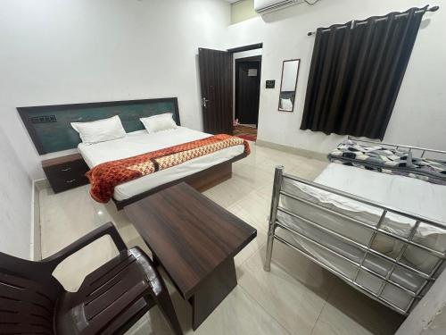 a bedroom with a bed and a chair and a tub at Hotel Sharda Palace in Deoghar