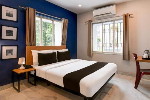 a bedroom with a large bed with blue walls at Super Collection O Bisarjan Ghat Formerly Eden Rocks in Kolkata