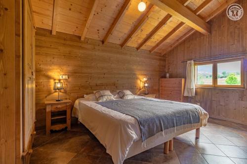 a bedroom with a bed in a wooden cabin at Gites le moulin in La Compôte