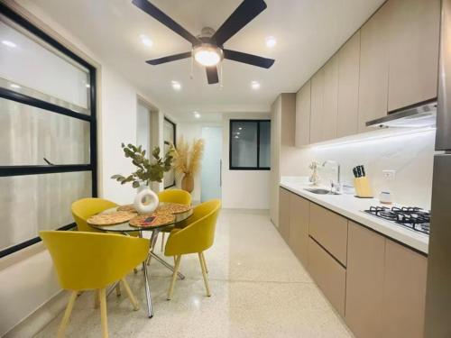 a kitchen with a table and chairs and a ceiling fan at Apartahotel MONACO in Ginebra