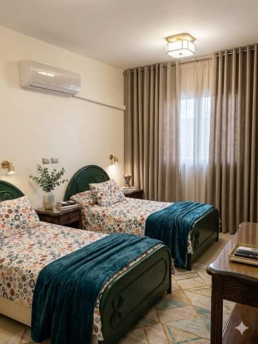 a hotel room with two beds and a table at شقة فاخرة موقع ممتاز in Aswan