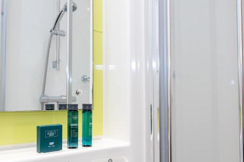 a bathroom with a mirror and books on a shelf at Single Ensuite Rooms In Central Preston in Preston