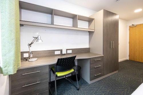 a room with a desk with a chair and a lamp at Single Ensuite Rooms In Central Preston in Preston