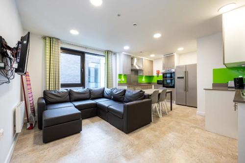 a living room with a couch and a kitchen at Single Ensuite Rooms In Central Preston in Preston