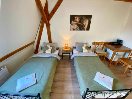 two twin beds in a room with a table at Młyn Wielisław Agroturystyka i Restauracja in Sędziszowa