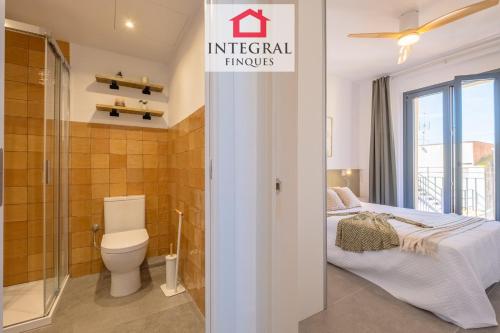 a bathroom with a bed and a toilet in a room at Les Voltes in Palamós