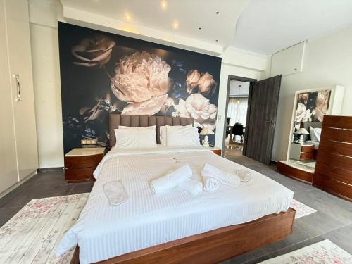 a bedroom with a large white bed with a painting on the wall at Tropical Apartment Hanioti in Hanioti