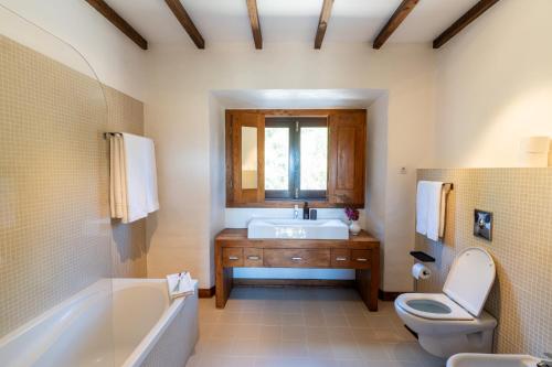a bathroom with a tub and a toilet and a sink at Casa do Cabeço in Maiorga